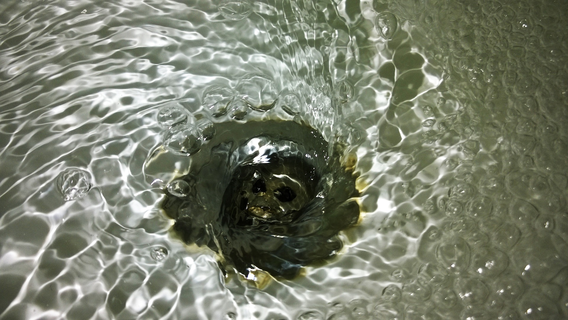 Water going down a sink drain on the One Stop Plumbing drain cleaning page
